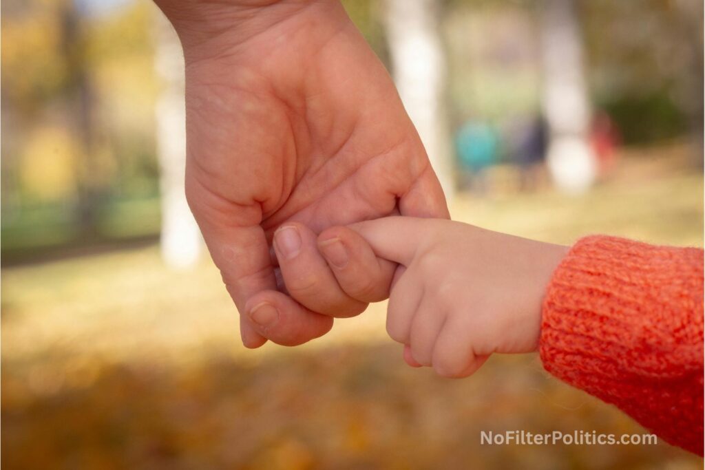 Parent and Child Holding Hands in Autumn Park